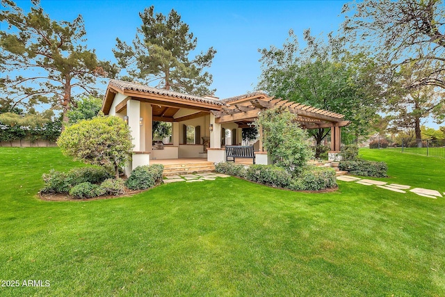rear view of property with stucco siding, a tiled roof, a pergola, and a yard
