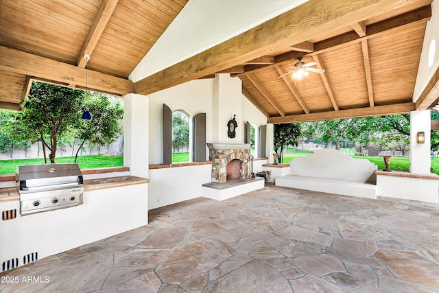 view of patio with exterior kitchen, grilling area, and an outdoor stone fireplace
