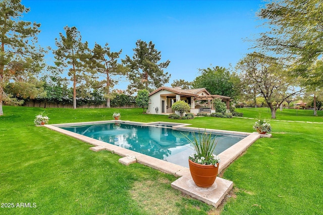 view of swimming pool with an outbuilding, a lawn, and a pool with connected hot tub