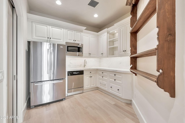 kitchen with visible vents, open shelves, white cabinets, appliances with stainless steel finishes, and light wood-type flooring