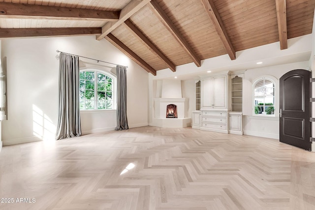unfurnished living room with baseboards, high vaulted ceiling, a warm lit fireplace, wood ceiling, and beamed ceiling