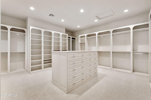walk in closet with attic access, visible vents, and light carpet