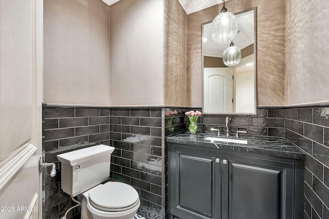 bathroom featuring a wainscoted wall, toilet, tile walls, and vanity
