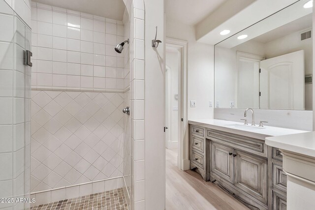 bathroom with visible vents, wood finished floors, recessed lighting, a shower stall, and vanity