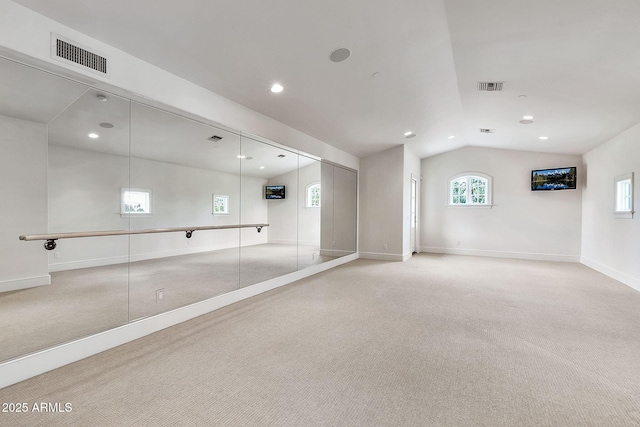 unfurnished room with visible vents, baseboards, carpet, and vaulted ceiling