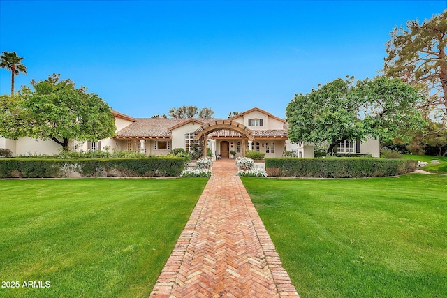 view of front of home with stucco siding, a tile roof, and a front lawn