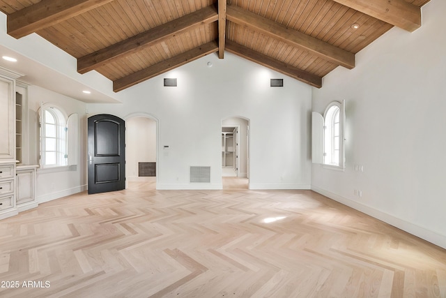 unfurnished living room with a wealth of natural light, visible vents, arched walkways, and high vaulted ceiling