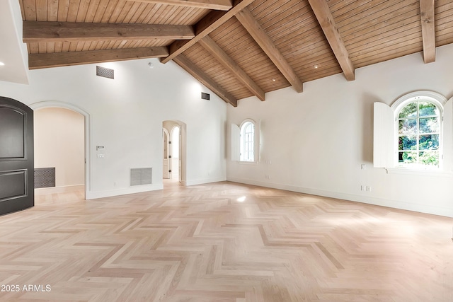 empty room with beamed ceiling, visible vents, arched walkways, and high vaulted ceiling