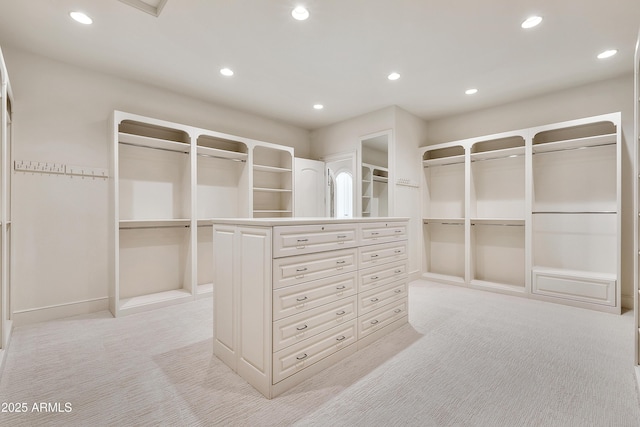 walk in closet featuring light colored carpet