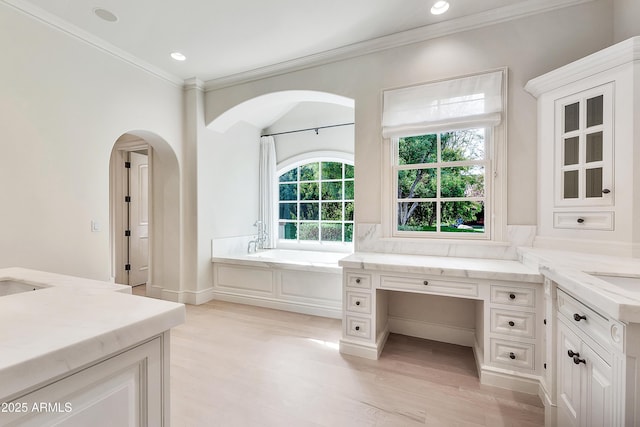 bathroom featuring a garden tub, ornamental molding, wood finished floors, recessed lighting, and vanity