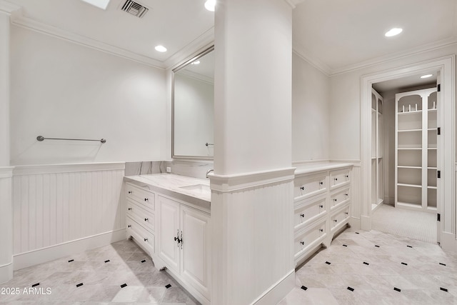 bathroom featuring visible vents, a wainscoted wall, vanity, and ornamental molding