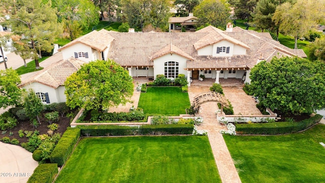 view of front of property featuring a front lawn, a tile roof, and stucco siding