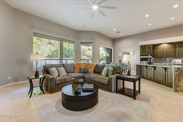 living room featuring light tile patterned floors, ceiling fan, and sink