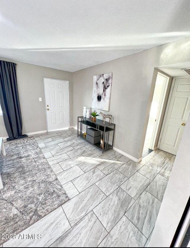 foyer entrance with a textured ceiling