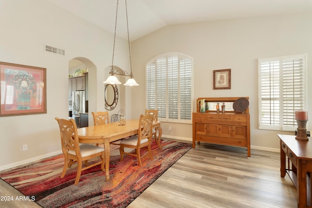 dining room featuring vaulted ceiling and light hardwood / wood-style flooring