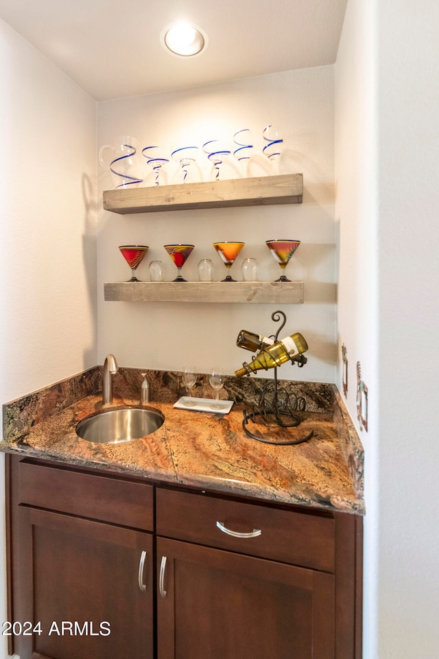 bar with dark stone countertops and sink