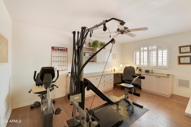 exercise room with ceiling fan and light hardwood / wood-style flooring