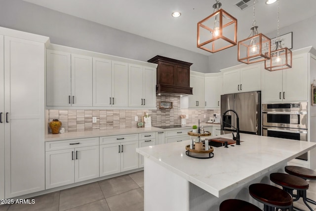 1884 E Stephens Dr, Tempe, AZ 85283 - kitchen with appliances with stainless steel finishes, a sink, a breakfast bar, decorative backsplash, and white cabinetry