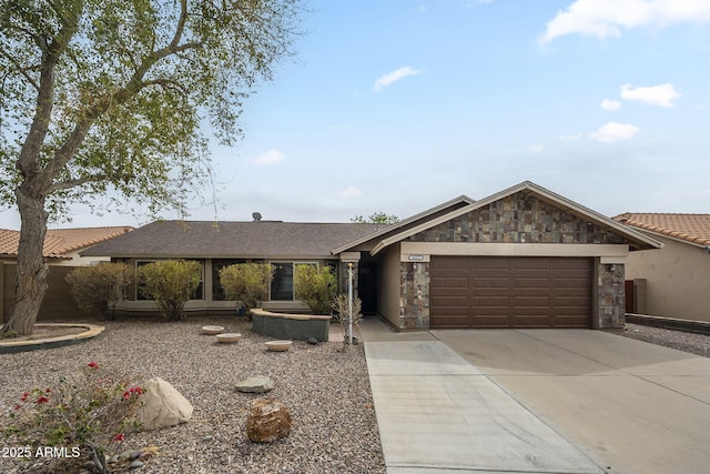 view of front of property featuring a garage, stone siding, and concrete driveway