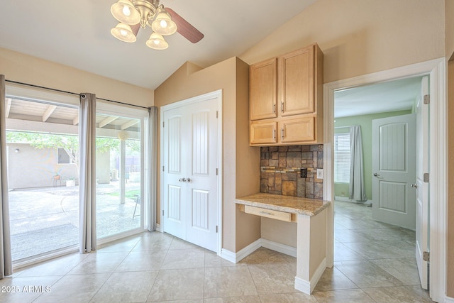 kitchen featuring light tile patterned floors, decorative backsplash, vaulted ceiling, light countertops, and light brown cabinetry