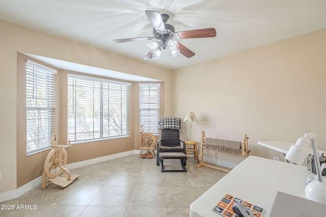 sitting room featuring ceiling fan, baseboards, and light tile patterned floors