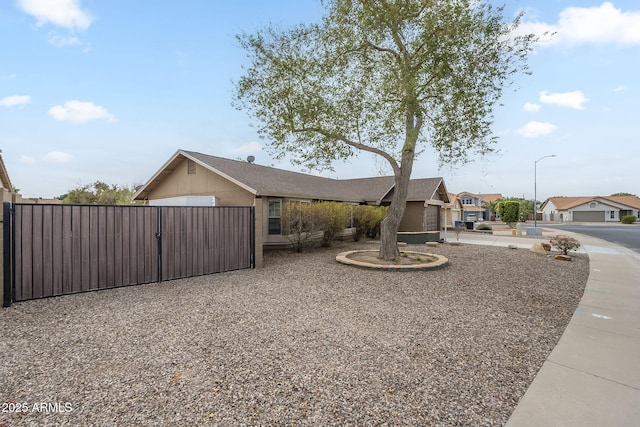 view of front of house featuring a residential view, fence, and a gate