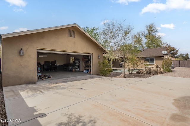 view of front of house featuring a garage, fence, and stucco siding