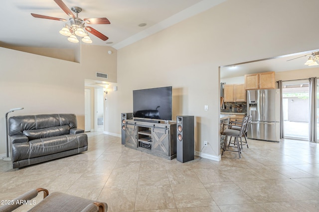 living area with high vaulted ceiling, baseboards, visible vents, and a ceiling fan