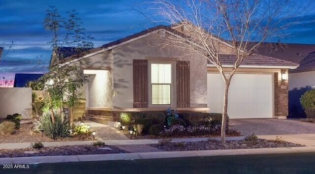 view of front of house with stucco siding, a garage, and concrete driveway