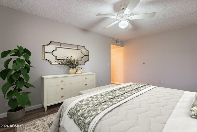 bedroom featuring ceiling fan, wood-type flooring, and a textured ceiling