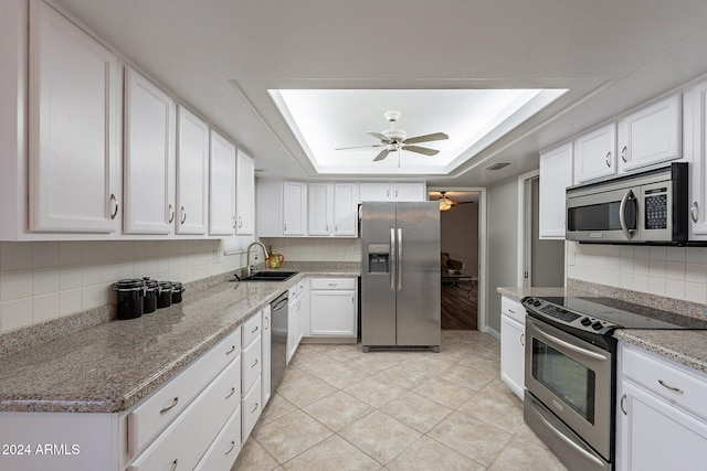 kitchen with white cabinetry, sink, ceiling fan, a raised ceiling, and appliances with stainless steel finishes