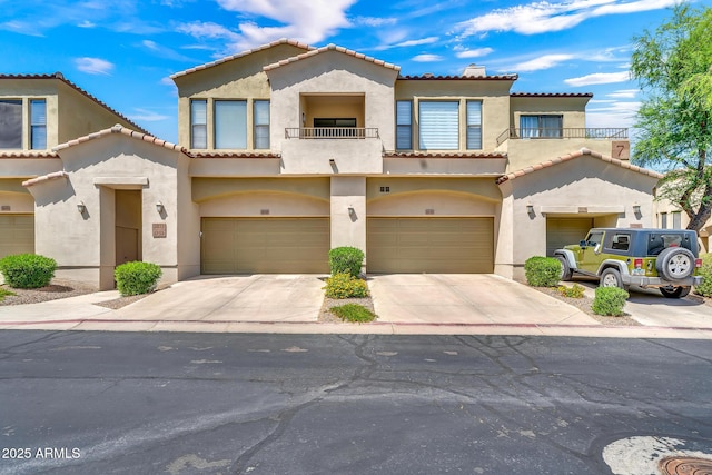 3131 E Legacy Dr Unit 1032, Phoenix, AZ 85042 - view of front facade with a balcony, stucco siding, a tiled roof, and concrete driveway