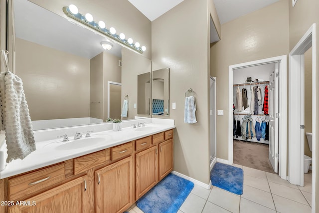3131 E Legacy Dr Unit 1032, Phoenix, AZ 85042 - bathroom with double vanity, toilet, a shower stall, tile patterned flooring, and a walk in closet