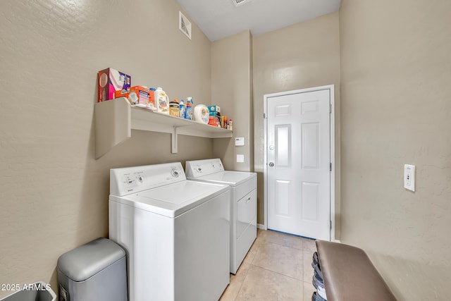 3131 E Legacy Dr Unit 1032, Phoenix, AZ 85042 - laundry room with washer and dryer, light tile patterned flooring, and a textured wall
