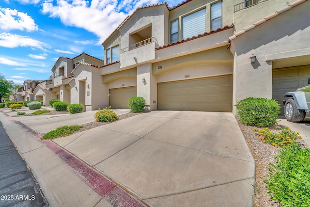 3131 E Legacy Dr Unit 1032, Phoenix, AZ 85042 - view of front of property featuring a balcony, a garage, stucco siding, and driveway