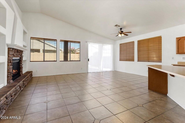 unfurnished living room featuring ceiling fan, a fireplace, light tile patterned flooring, and lofted ceiling