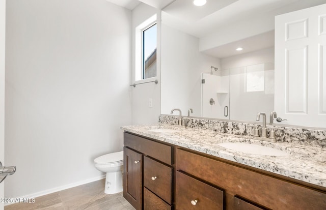 21292 N 270th Dr, Buckeye, AZ 85396 - bathroom featuring baseboards, double vanity, toilet, a shower stall, and recessed lighting