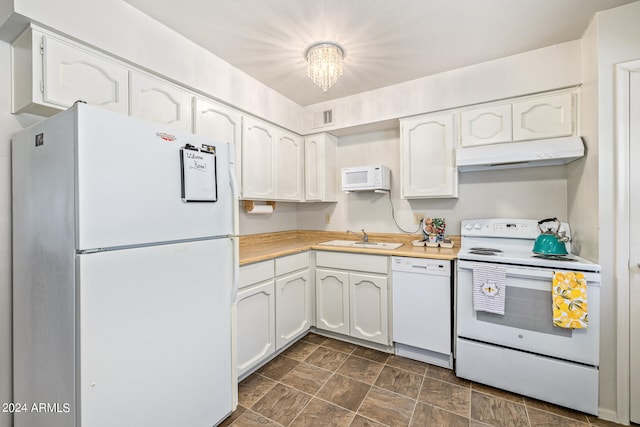 kitchen featuring sink, white appliances, decorative light fixtures, white cabinetry, and a notable chandelier