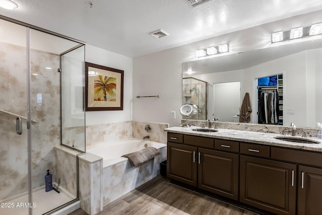 bathroom featuring independent shower and bath, vanity, and hardwood / wood-style floors