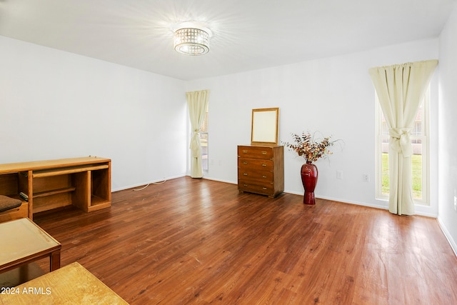 spare room featuring dark hardwood / wood-style flooring and a chandelier