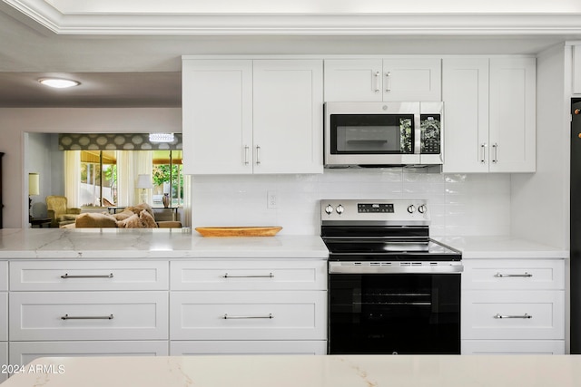 kitchen featuring stainless steel appliances, backsplash, and white cabinetry