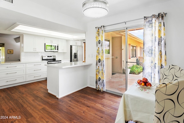 kitchen with white cabinets, kitchen peninsula, stainless steel appliances, dark hardwood / wood-style floors, and decorative backsplash