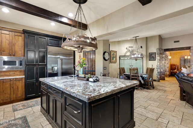 21230 S 156th St, Gilbert, AZ 85298 - kitchen with built in appliances, stone tile flooring, recessed lighting, a center island with sink, and dark cabinetry
