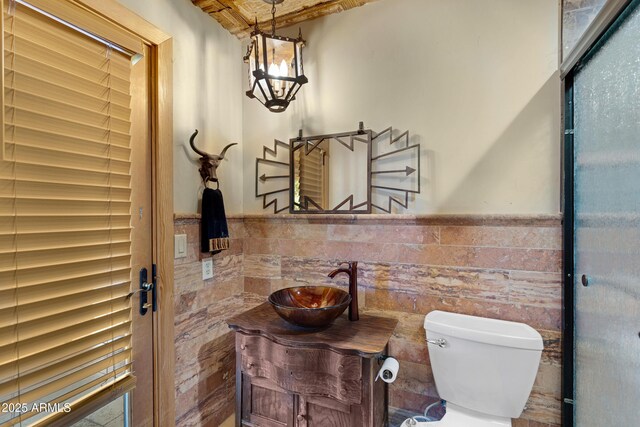 21230 S 156th St, Gilbert, AZ 85298 - bathroom with toilet, tile walls, vanity, a wainscoted wall, and a chandelier