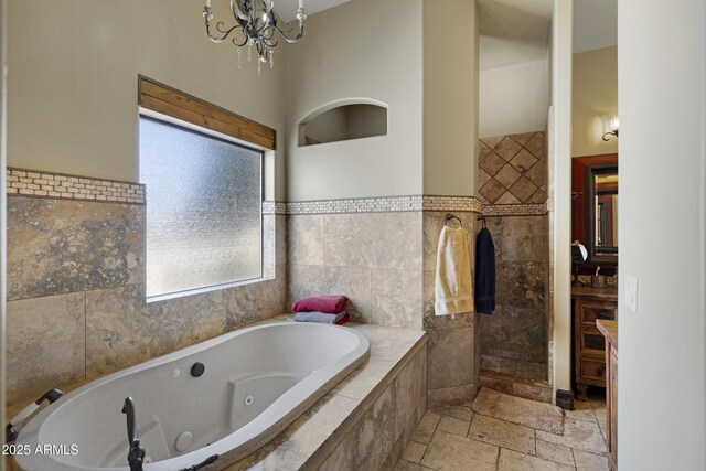 21230 S 156th St, Gilbert, AZ 85298 - full bath featuring tile walls, a jetted tub, stone tile floors, and a chandelier