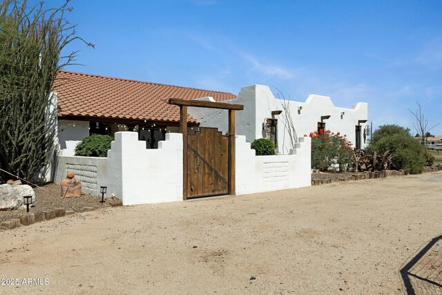 21230 S 156th St, Gilbert, AZ 85298 - view of home's exterior with a gate, stucco siding, and a tiled roof