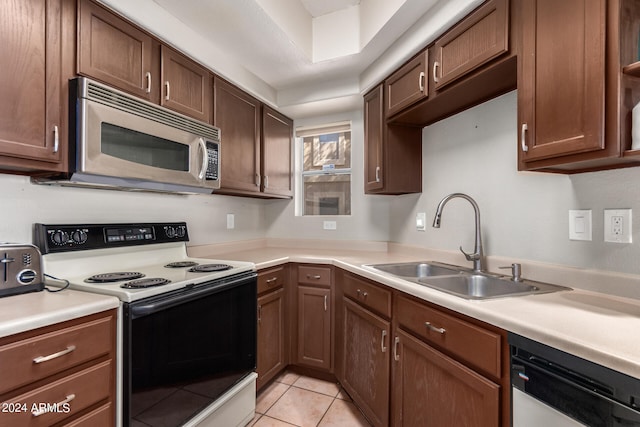 kitchen featuring light tile patterned floors, appliances with stainless steel finishes, and sink