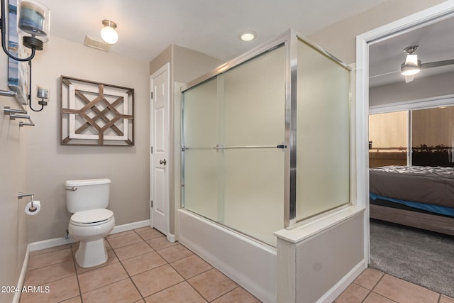 bathroom with tile patterned floors, combined bath / shower with glass door, and toilet