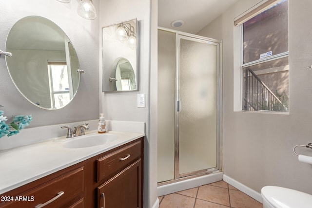 bathroom with a shower with door, vanity, toilet, and tile patterned flooring