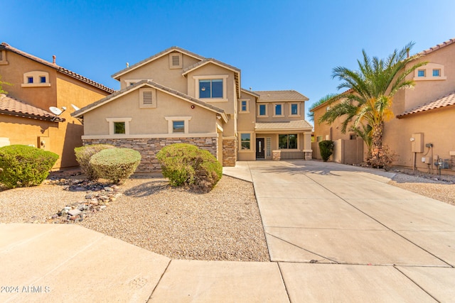 view of front of property featuring stucco siding, fence, a garage, stone siding, and driveway